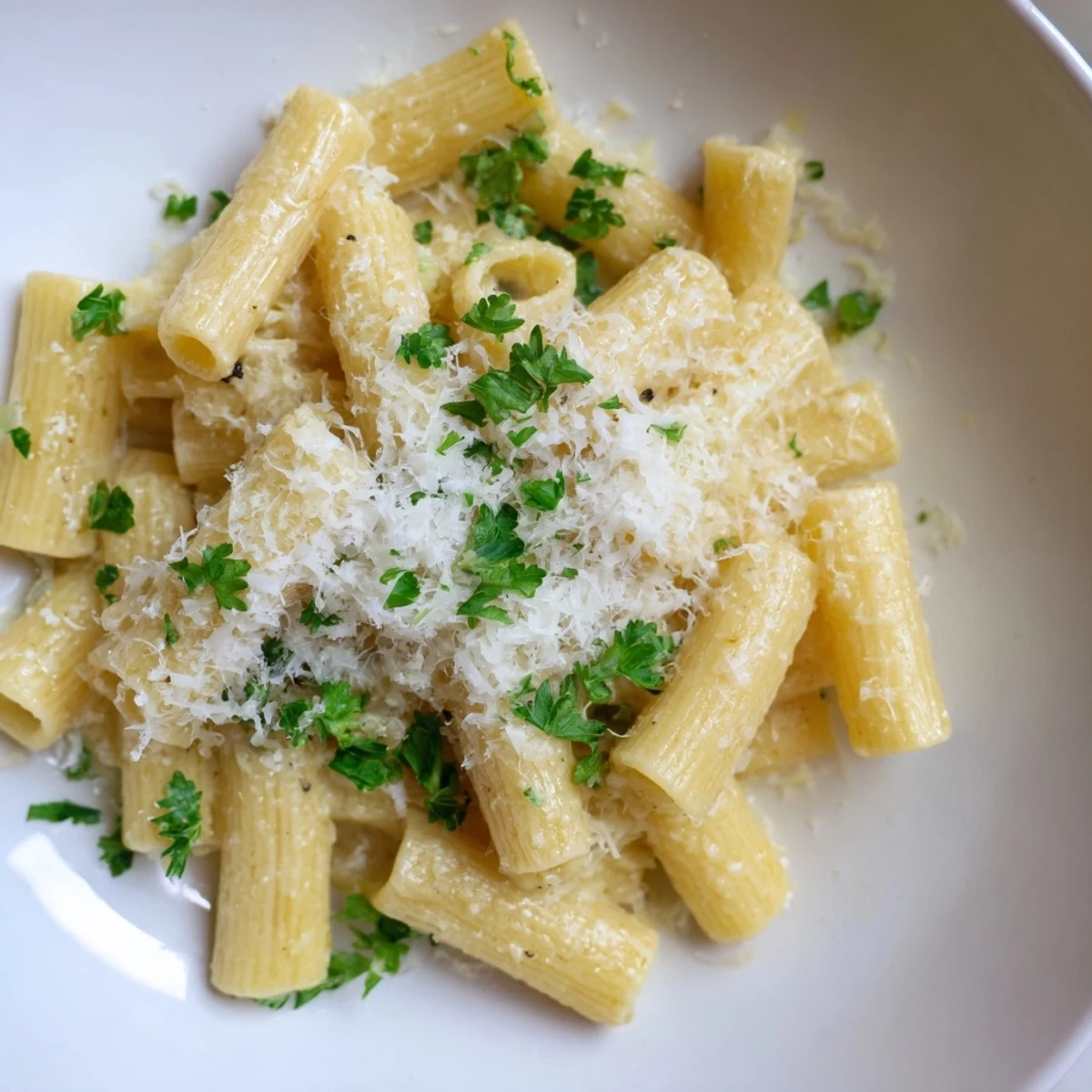 Close-up of golden 15-Minute Garlic Parmesan Pasta, generously topped with Parmesan and fresh parsley.