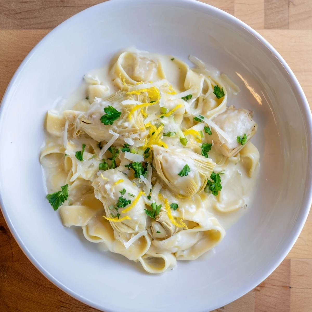 Close-up of the delicious Creamy Lemon Artichoke Pasta featuring Parmesan cheese and lemon.