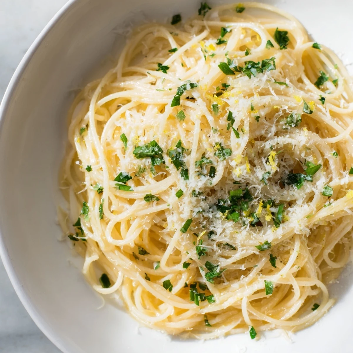Golden, glistening Lemon Capellini, ready to be twirled and enjoyed with fresh herbs and Parmesan.