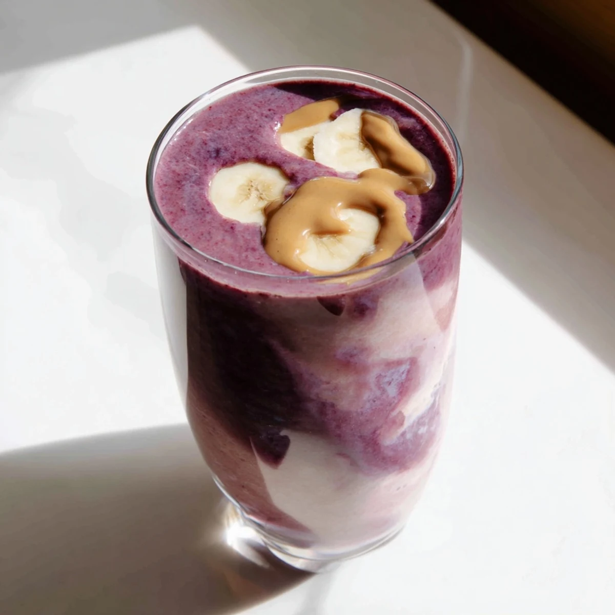 Cherry Almond Smoothie garnished with extra cherries and almond slices, served over ice for a refreshing breakfast or snack.