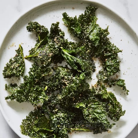 Freshly seasoned crispy kale chips, a baked snack with smoky paprika and garlic flavors.