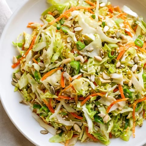 Close-up of freshly tossed Cabbage-Core Slaw Salad, showcasing colorful veggies and a nutty vinaigrette for a refreshing side.