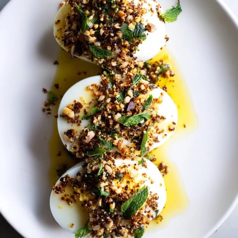 Vibrant image of Dukkah-Spiced Eggs, showcasing golden yolks and a fragrant spice topping alongside fresh pita.