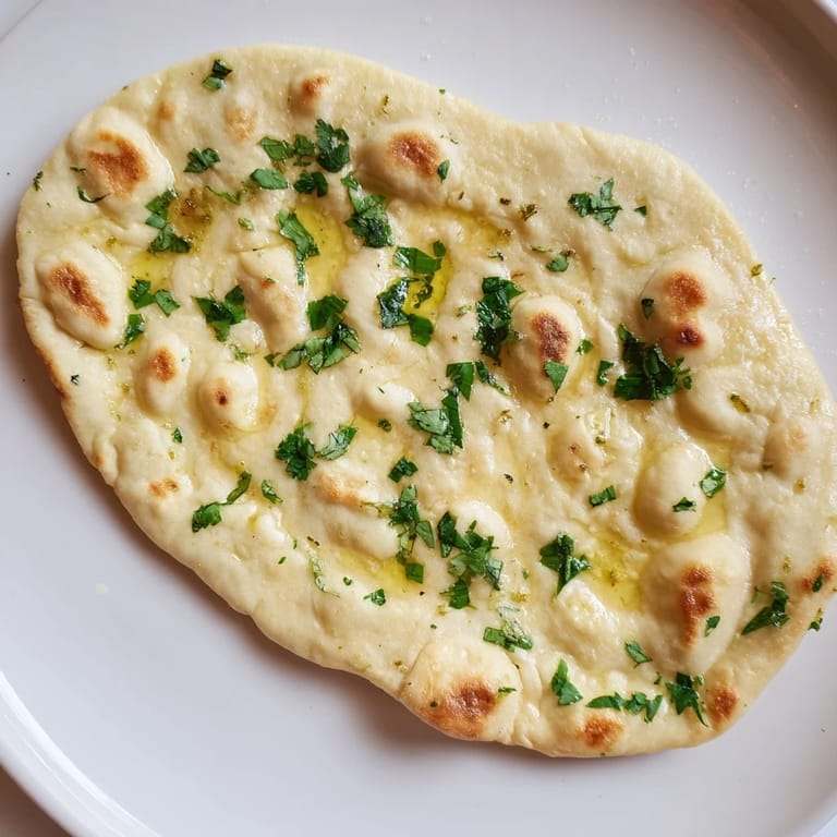 Warm and aromatic Homemade Garlic Naan, a fluffy Indian flatbread perfect for a delicious meal.