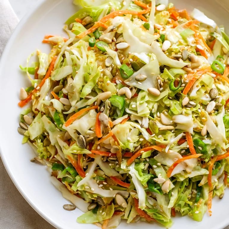 Close-up of freshly tossed Cabbage-Core Slaw Salad, showcasing colorful veggies and a nutty vinaigrette for a refreshing side.