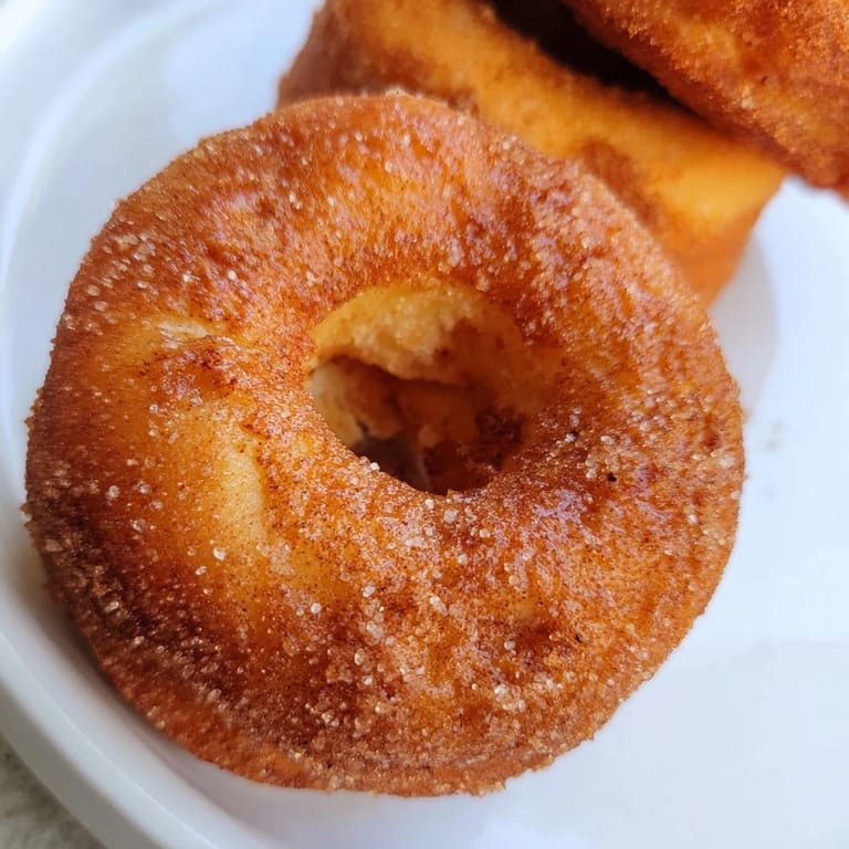 Close-up of fluffy 1-Minute Air Fryer Donuts, invitingly dusted with cinnamon sugar, perfect for a quick treat.