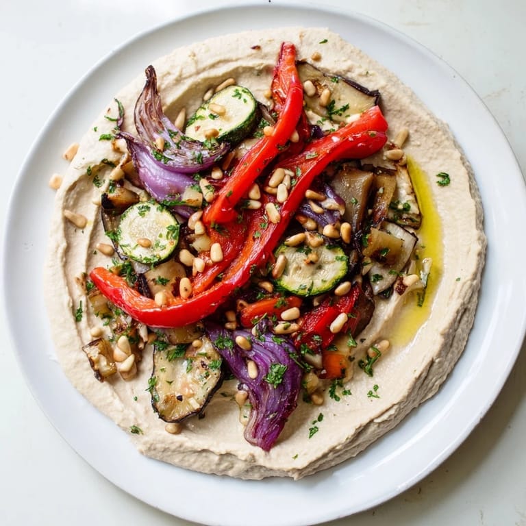 Vibrant hummus roasted veggies appetizer: a close-up of smoky roasted eggplant and zucchini.